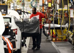 a technician uses a lift to move a back seat bench into a new Altima on the assembly line at the Nissan Canton Vehicle Assembly Plant in Canton