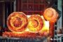 Red-hot forged metal rings glow after heating in a high-temperature industrial furnace during the forging process.